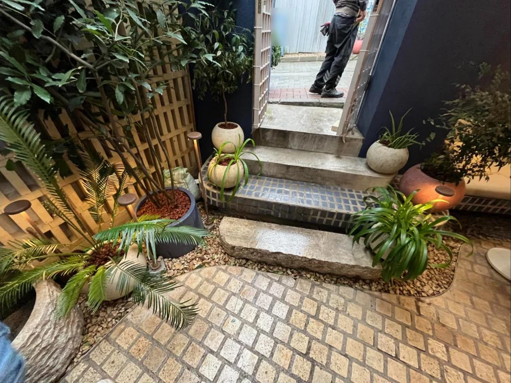 Arnavutköy'deki mekânın giriş avlusunda saksı ve toprak bitkileri